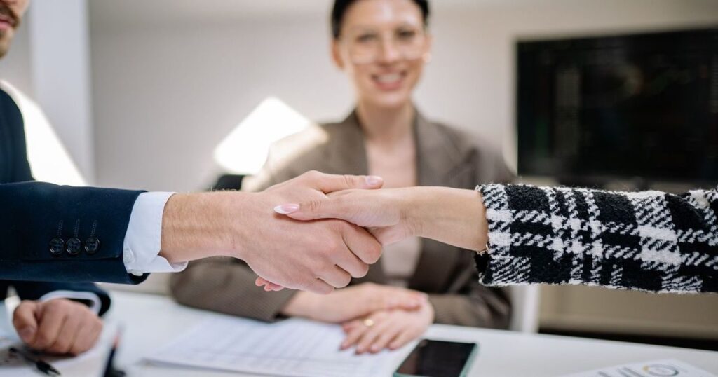 Aperto de mãos selando a compra e venda de um negócio em reunião
