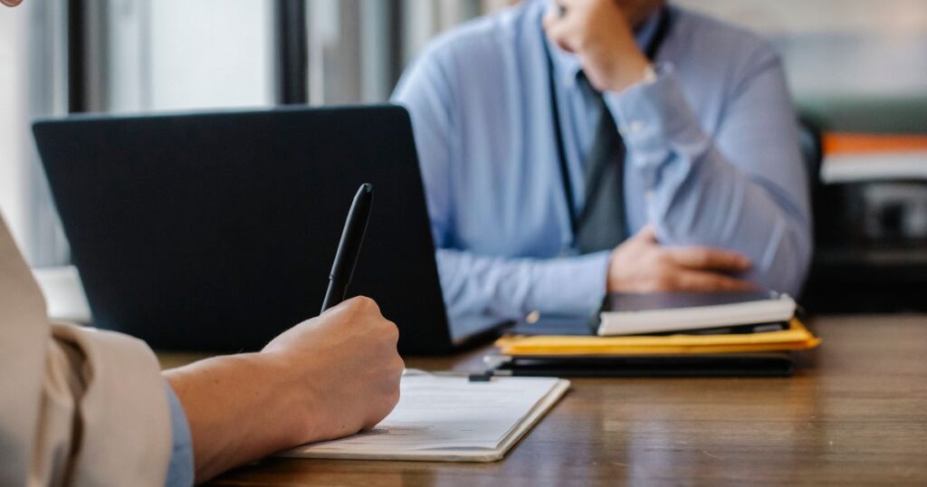 Gestor documentando um desligamento por justa causa sobre a mesa do escritório