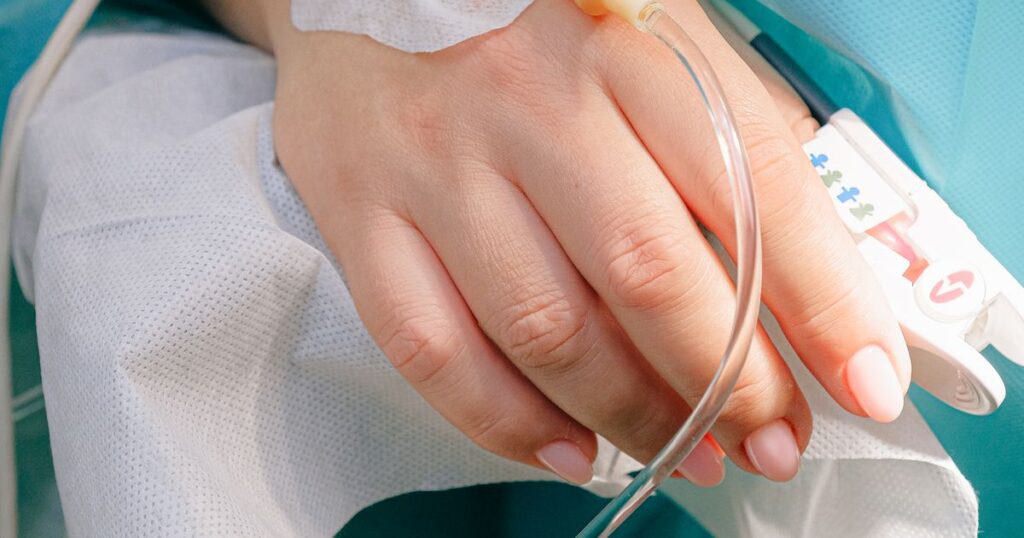 Mão de paciente recebendo a imunoterapia intravenosa, como o nivolumabe (Opdivo), negada pelo plano de saúde