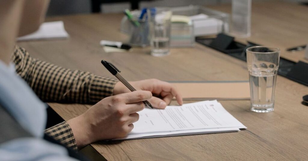 Empresário lendo o contrato de capital de giro na mesa de reunião antes de renegociar a dívida da empresa com o banco